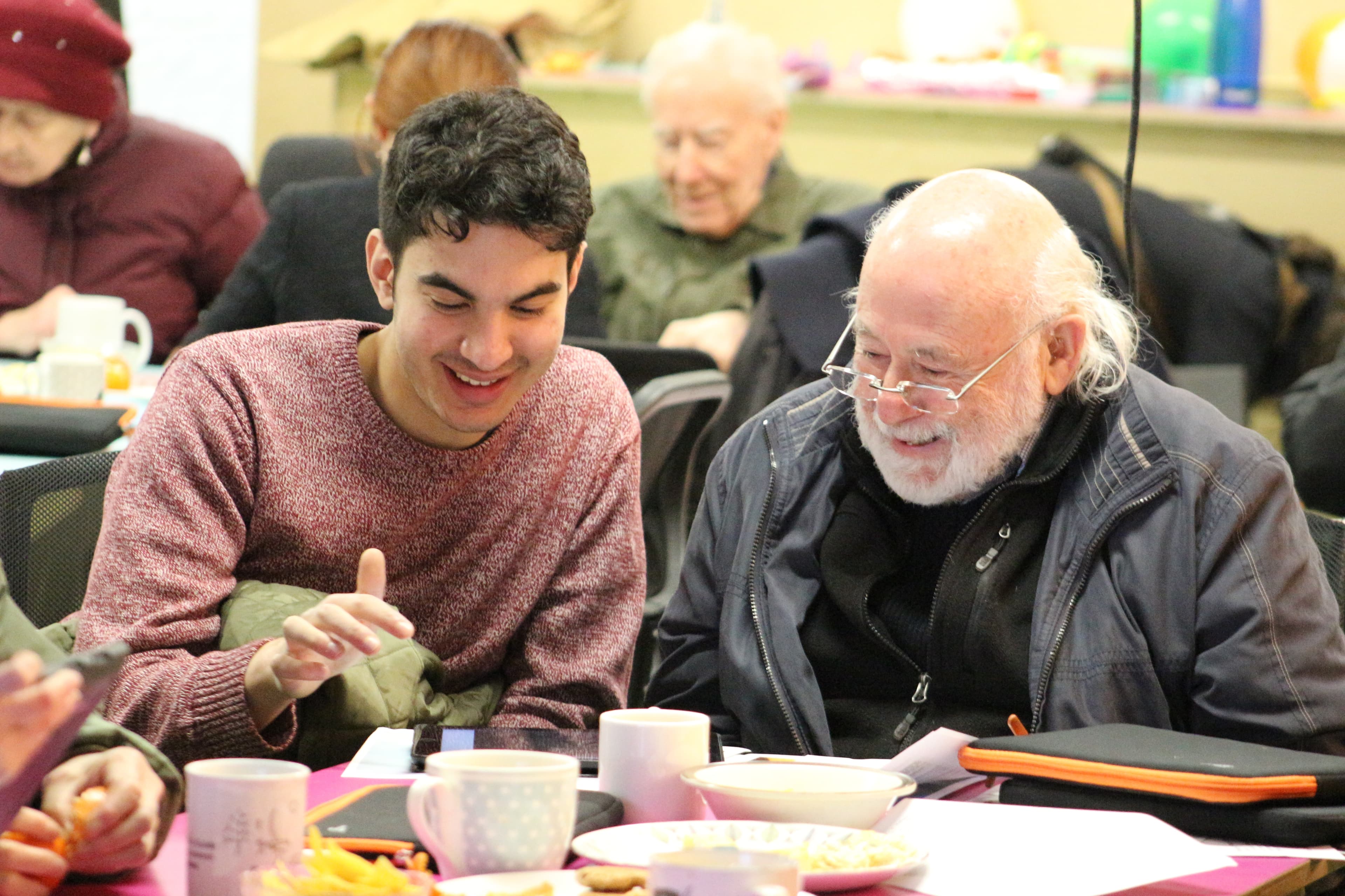 Young man and old man discussing technology