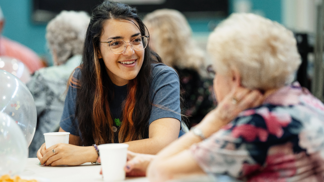 Manchester Cares social club picturing two women engaged in conversation.