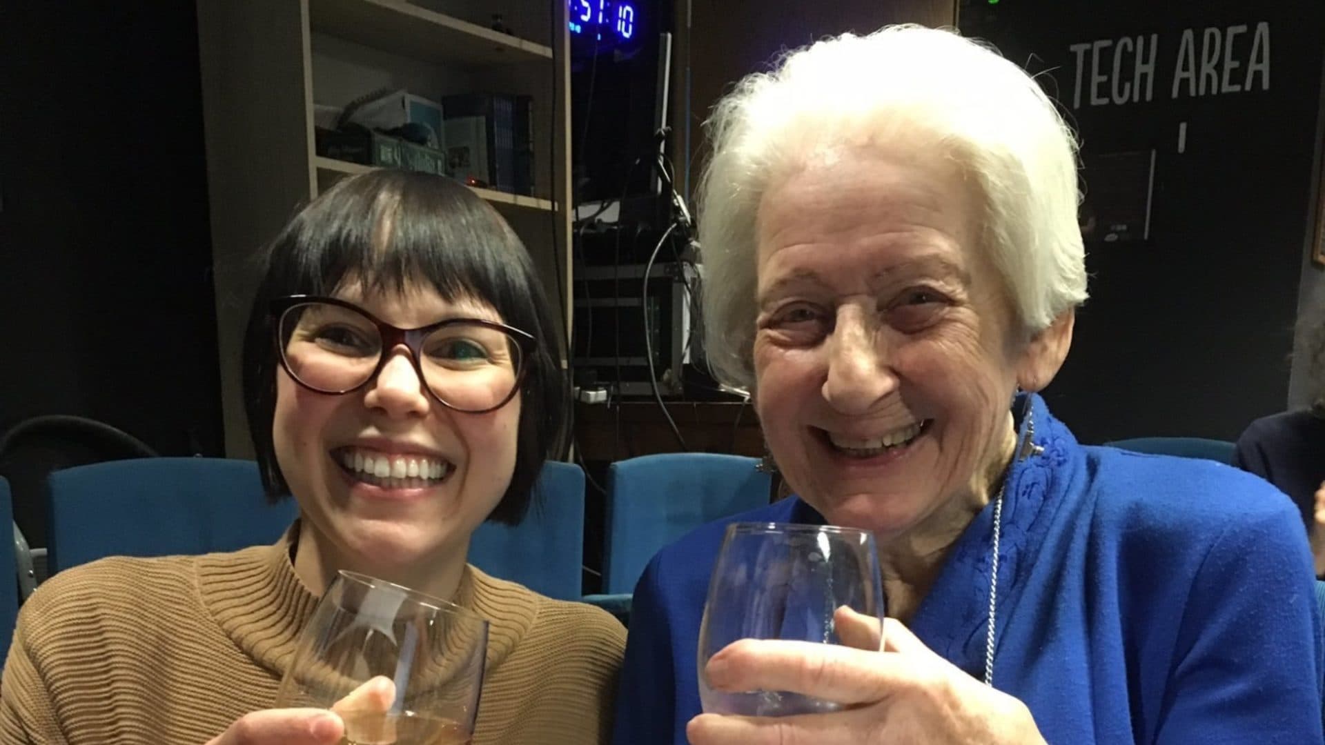 Two women posing together with a drink