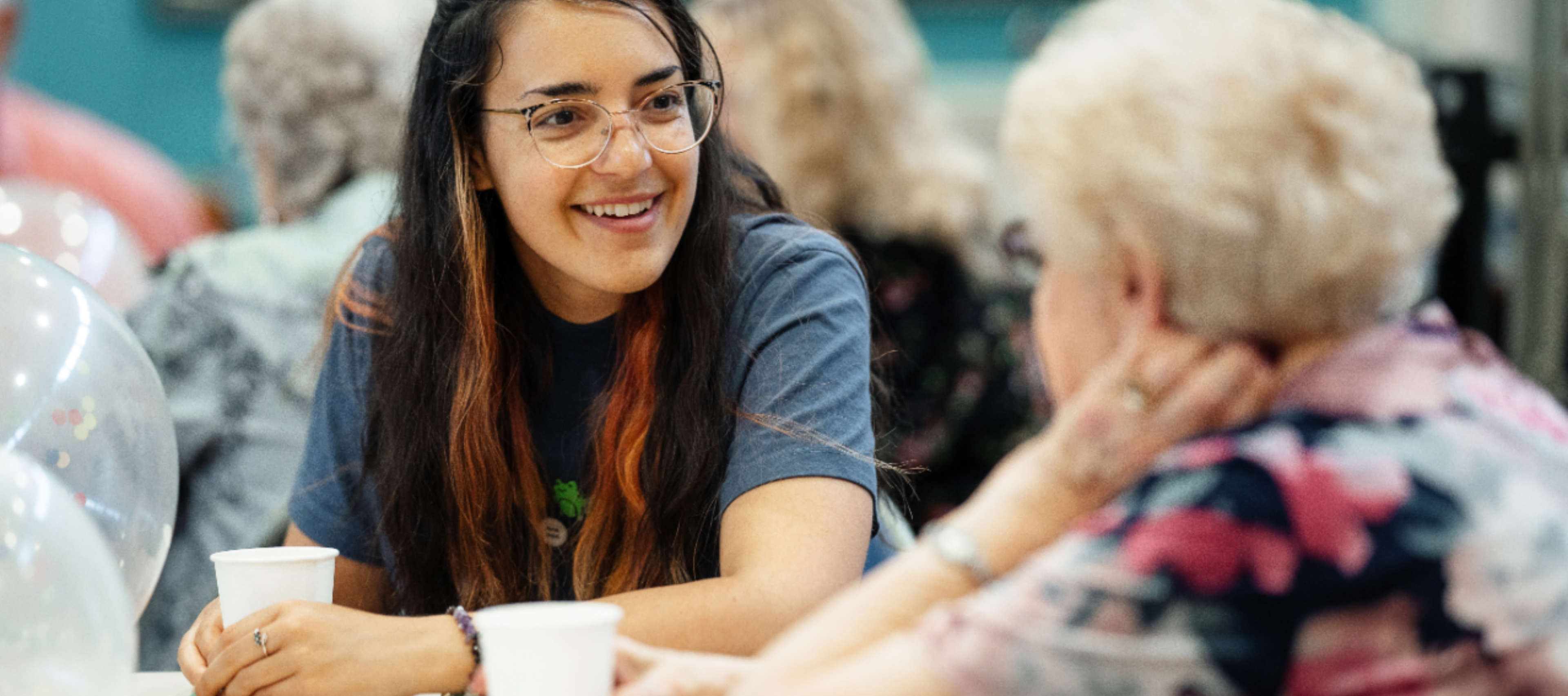 Manchester Cares social club picturing two women engaged in conversation.