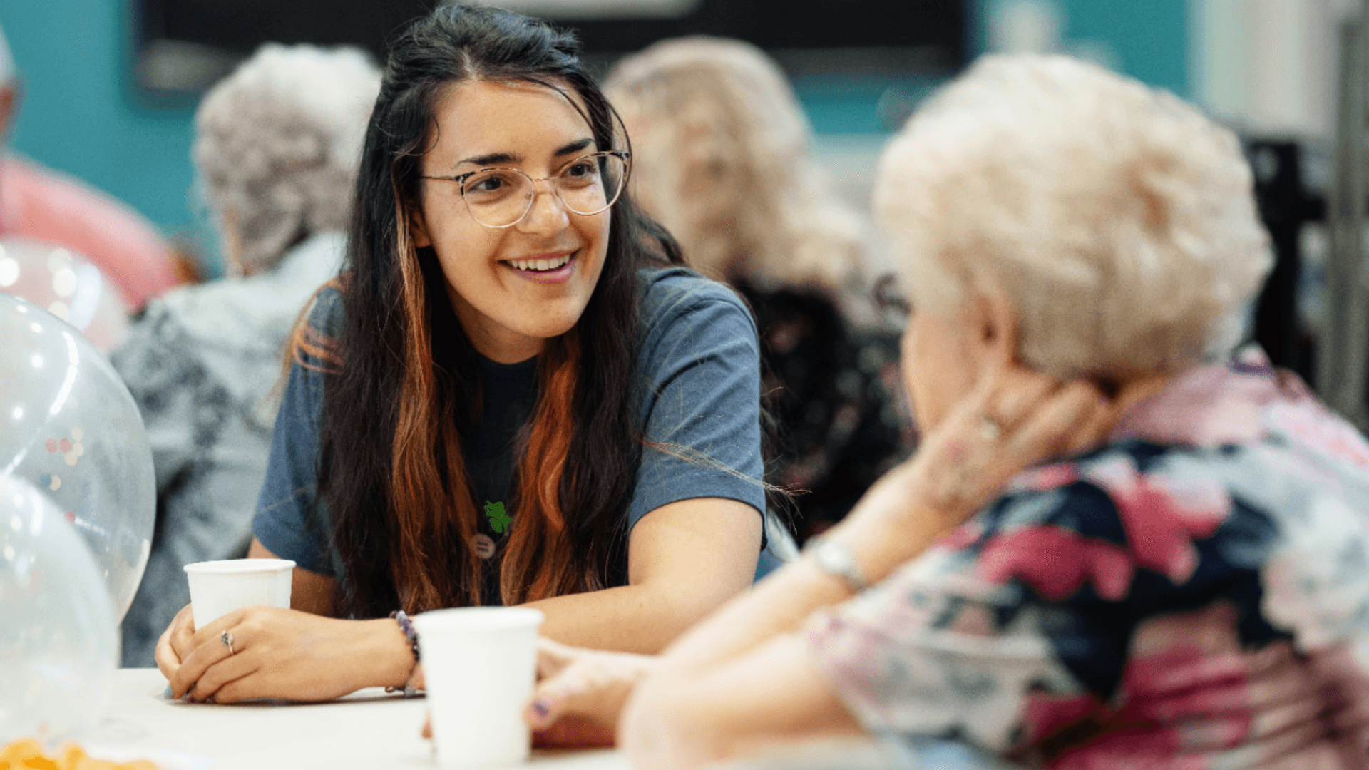 Manchester Cares social club picturing two women engaged in conversation.